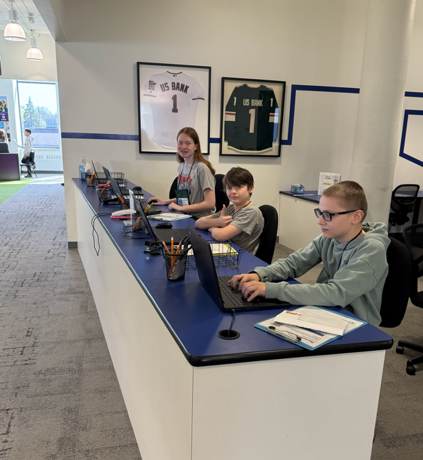 Three students working at a desk.