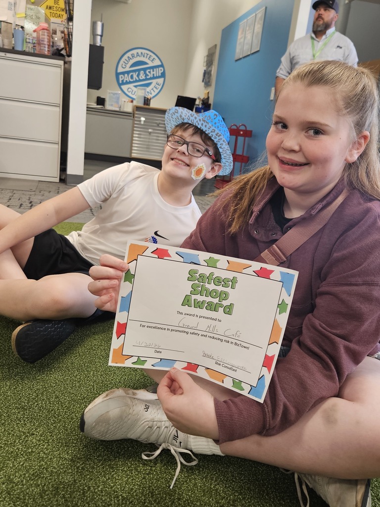 Two students smiling with a certificate.