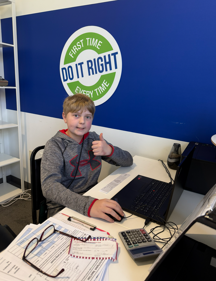 Student working on a laptop and giving a thumbs up!