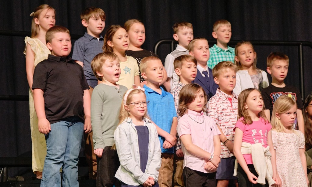 Group of boys and girls singing at their concert.