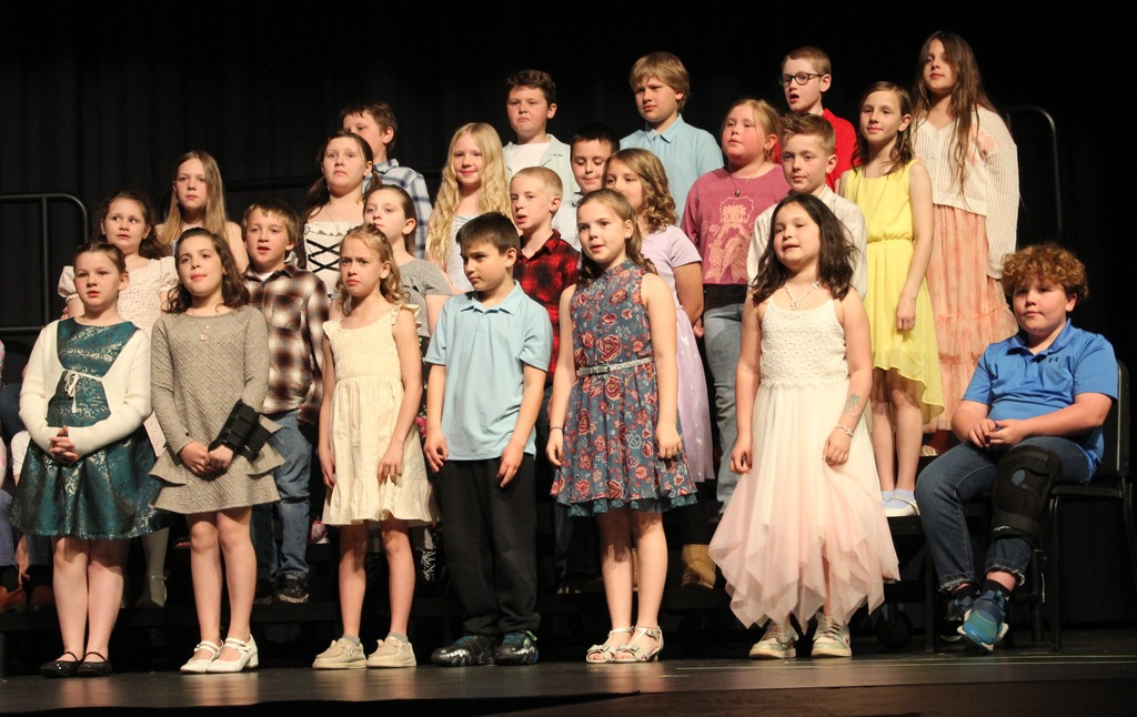 Students standing on the risers singing.