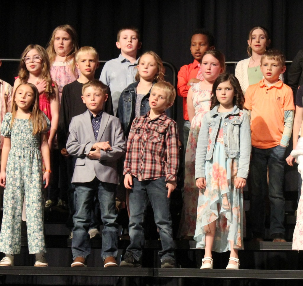 A group of students singing on stage.