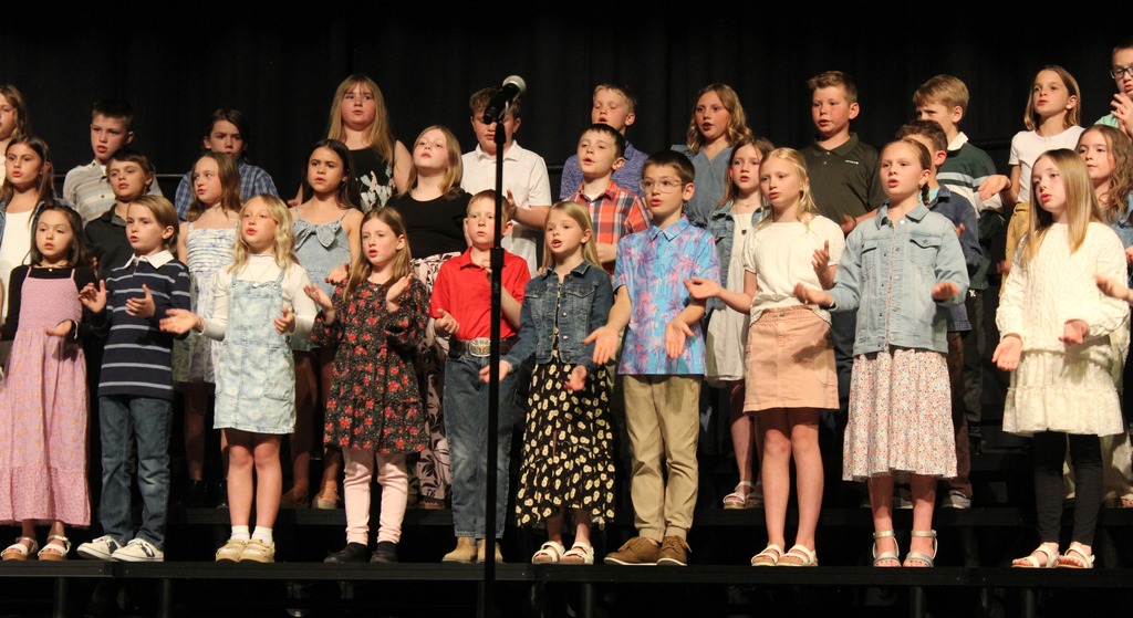 A grou pof all students on the stage singing.