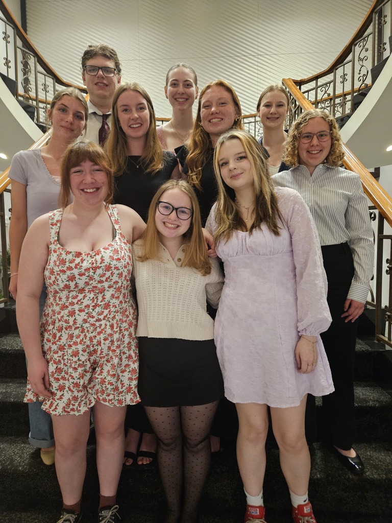 Students smiling on a staircase.