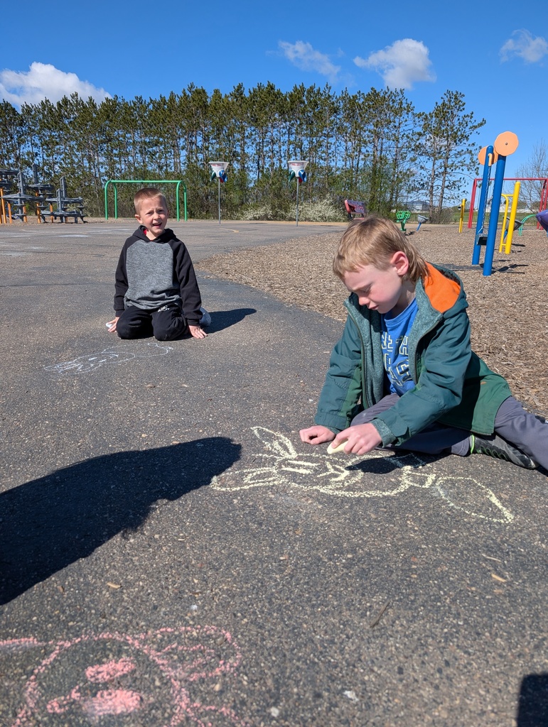 Students coloring and smiling with sidewalk chalk.