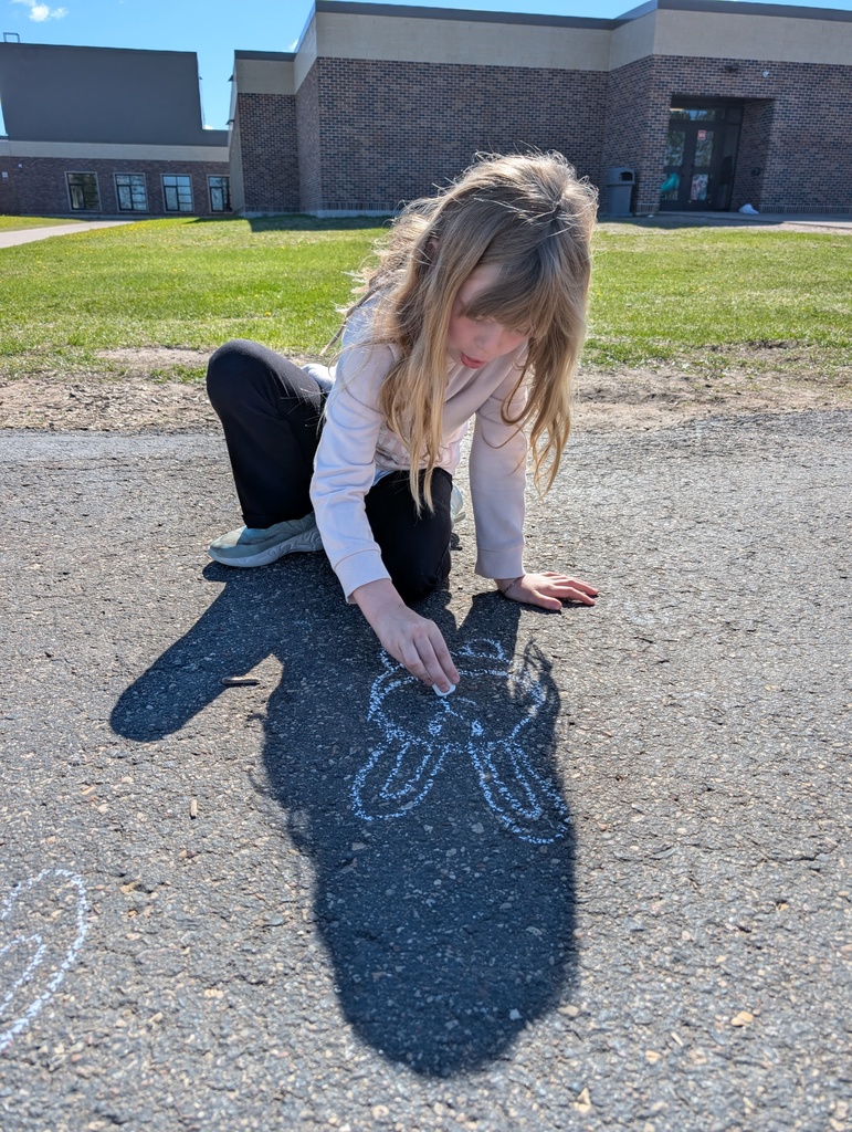 A girl drawing a rabbit on the blacktop outside.
