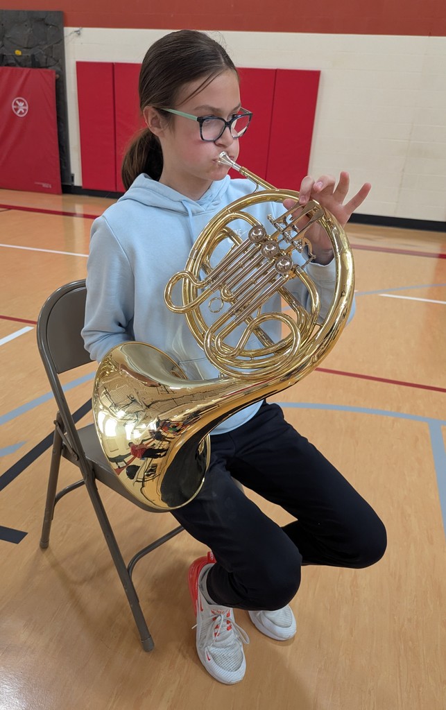 Student sitting and trying out an instrument.