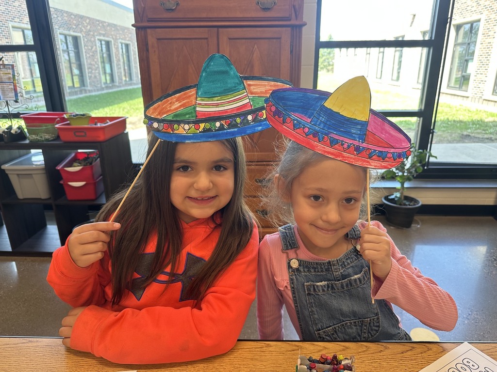 Two smiling students with sombreros