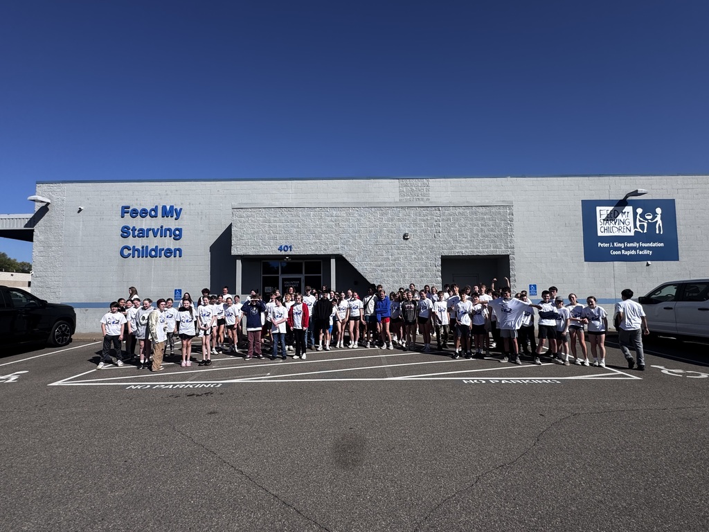 Group photo of staff and students in front of Feed My Starving Children.