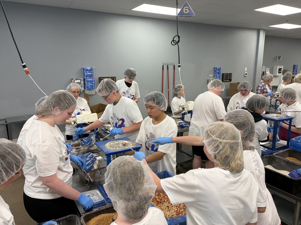 Students and staff working on packing meals.