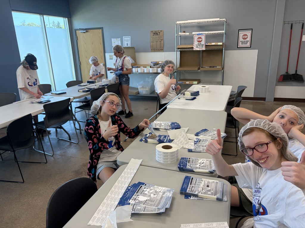 students working at a table with thumbs up!