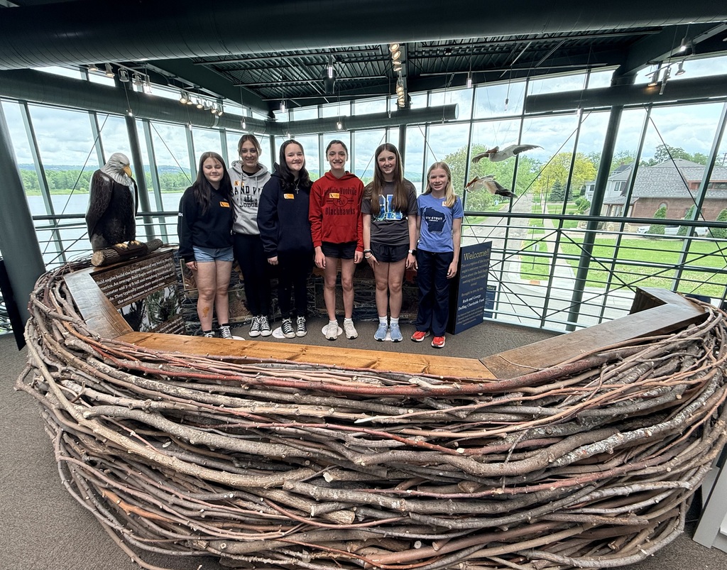 Students smiling in a fake bird nest.