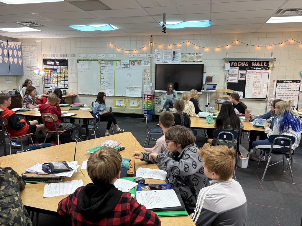 A classroom of students listening to poetry.