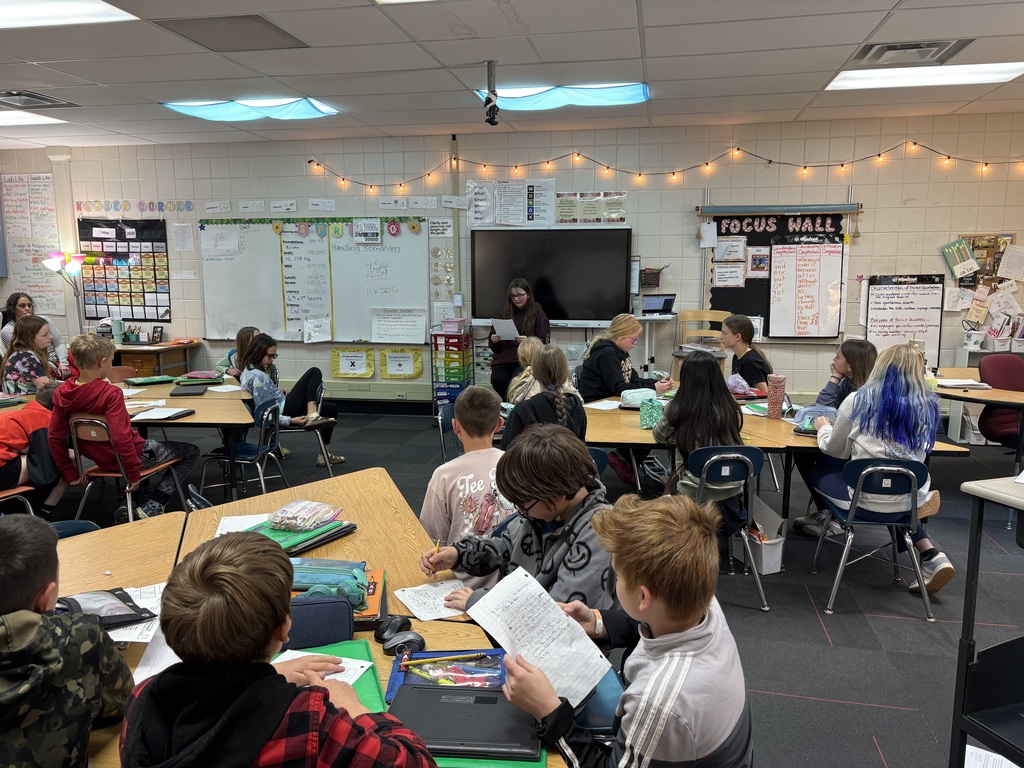 A student reading her poetry in front of the class.
