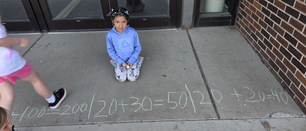 Kindergartner smiling with her math problems.