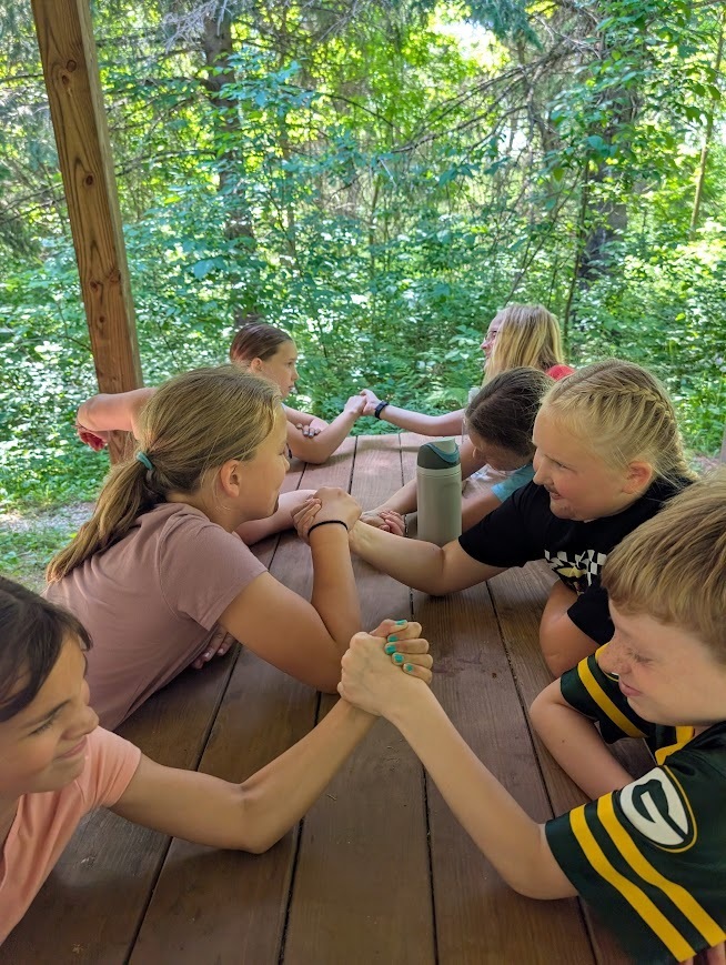 A group of students arm wrestling.