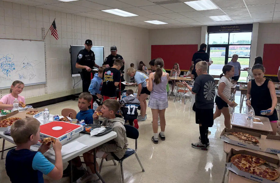 Students eating pizza with the Baldwin Police Department.
