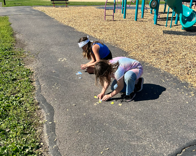 Two students putting together a puzzle during a challenge on the playground.