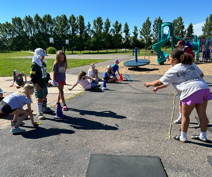 Students throwing rings and competing on the playground.