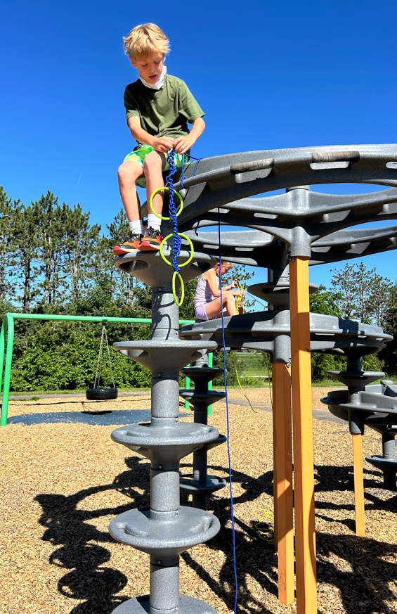 Studenting participating in a challenge on the playground equipment.