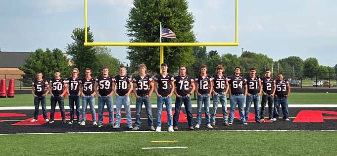 Senior football players standing in the endzone of the football field.