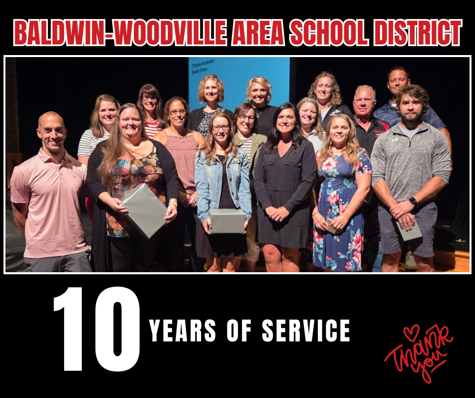 A graphic celebrating 10 years of service at the Baldwin-Woodville Area School District. A group photograph shows 14 smiling staff members posing together in three rows on a stage, with several holding wrapped gifts and a projection screen visible behind them. Large red and white text at the top reads "BALDWIN-WOODVILLE AREA SCHOOL DISTRICT." The bottom of the image features a large white "10" followed by "YEARS OF SERVICE" in bold white text, alongside a red handwritten "Thank you" graphic with a small heart.