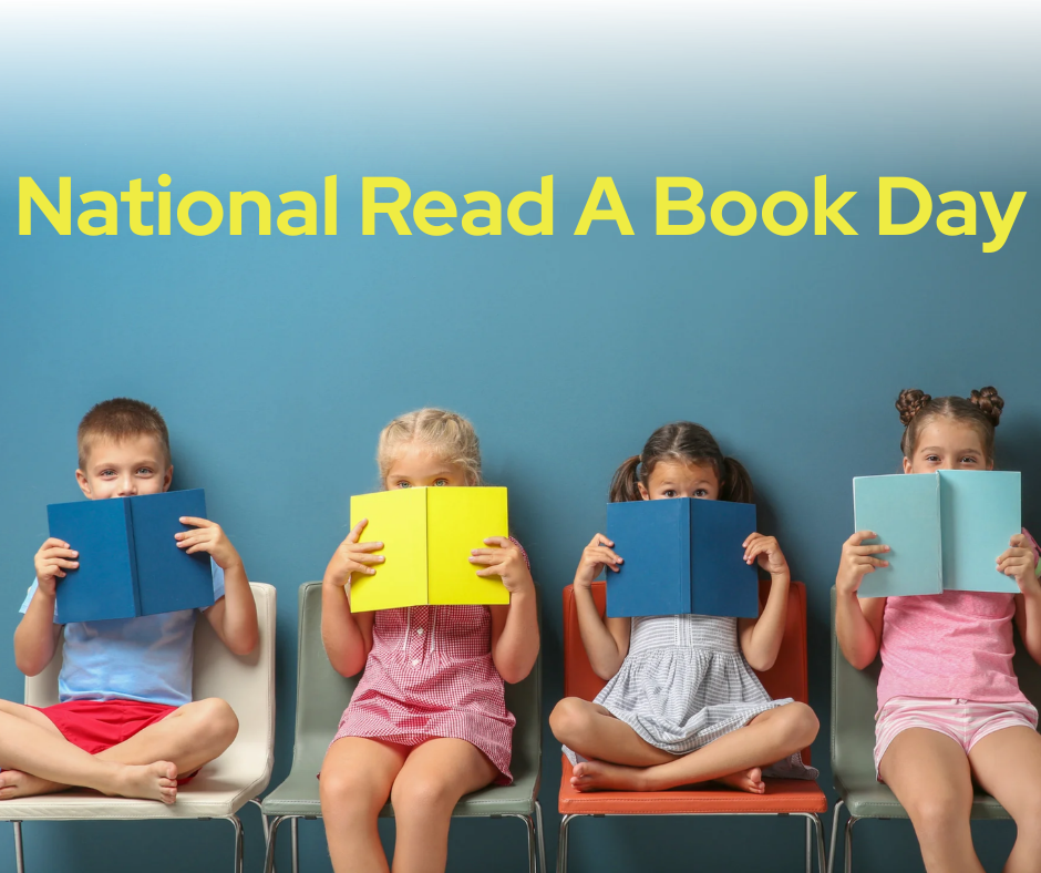 Four young children sit side-by-side in colorful chairs against a blue wall, holding open books up to cover their faces. Above them, yellow text reads "National Read a Book Day."