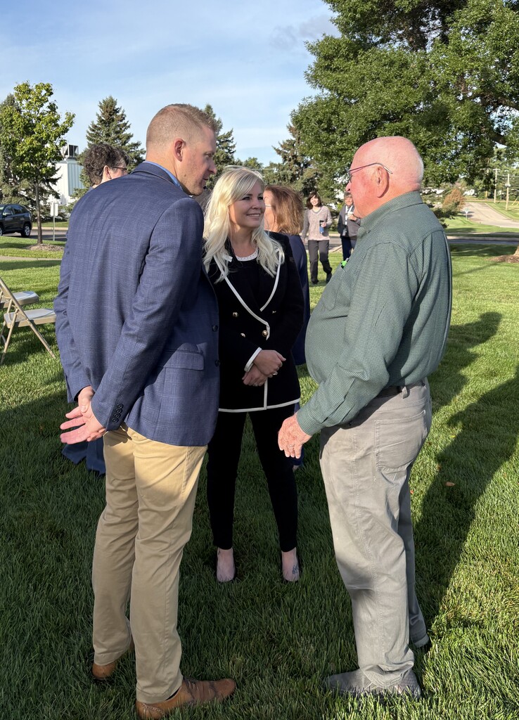 Three business partners smiling and talking.