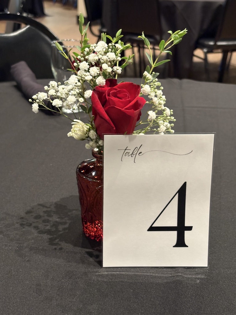 Table four with a small red vase and flowers