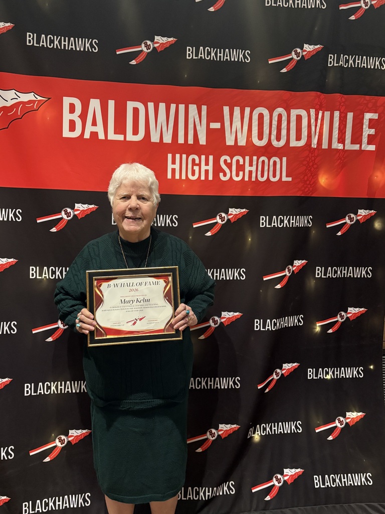 Mary Kelm in 2026 standing in front of the Baldwin-Woodville High School backdrop with her certificate.