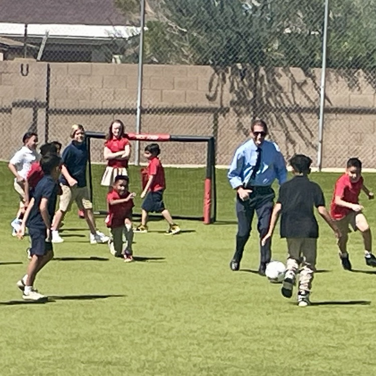 kids playing soccer with the principal 