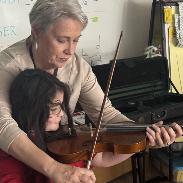 child and teacher playing violin 