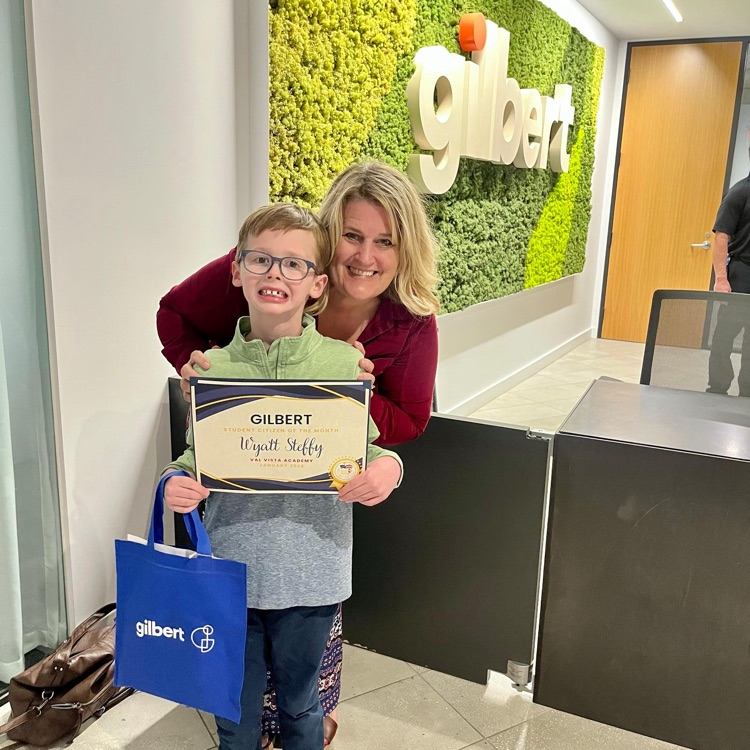 student holding award with teacher