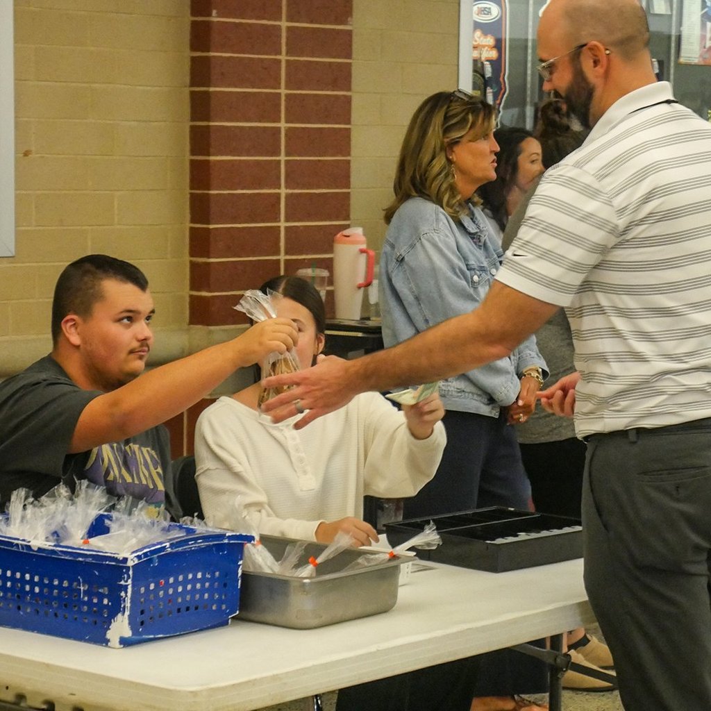 A GHS student hands Mr. Crossland his cookies.