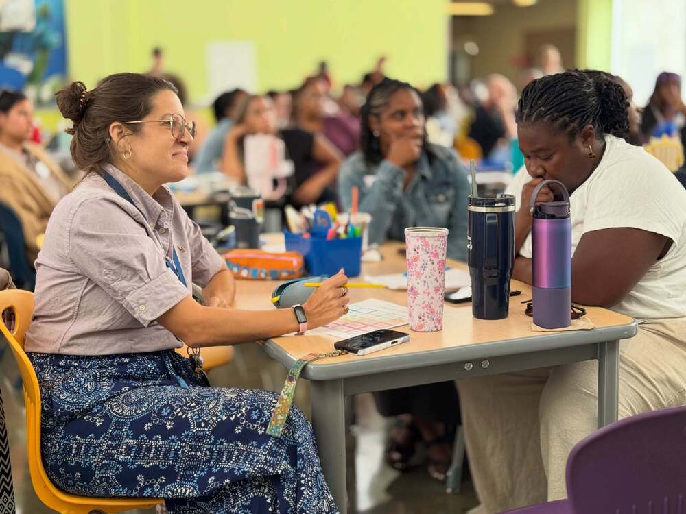 Two employees sitting at a desk during a professional development training