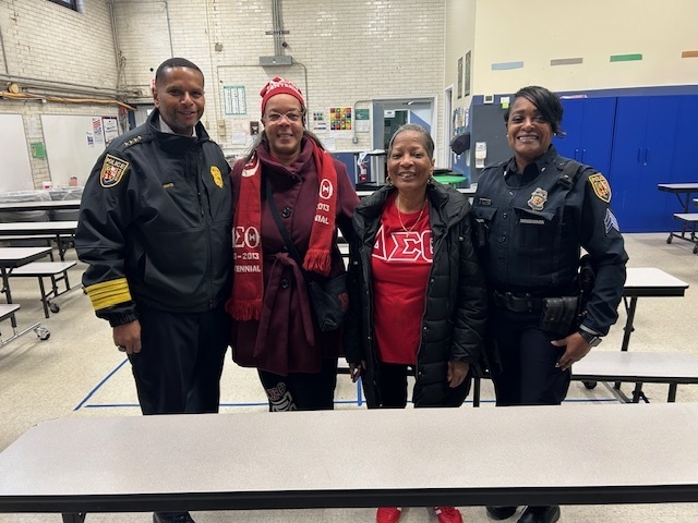 School Police hand out coats and pose for photos at Midtown Academy 