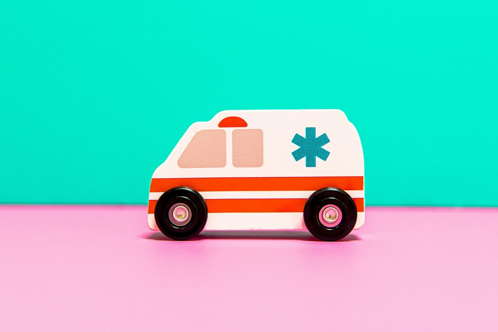 toy ambulance on pink floor with green background