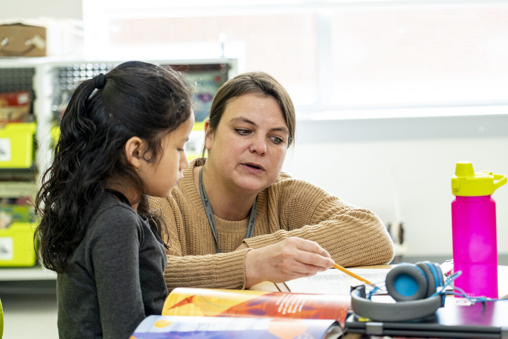 Teacher assisting one student at their desk