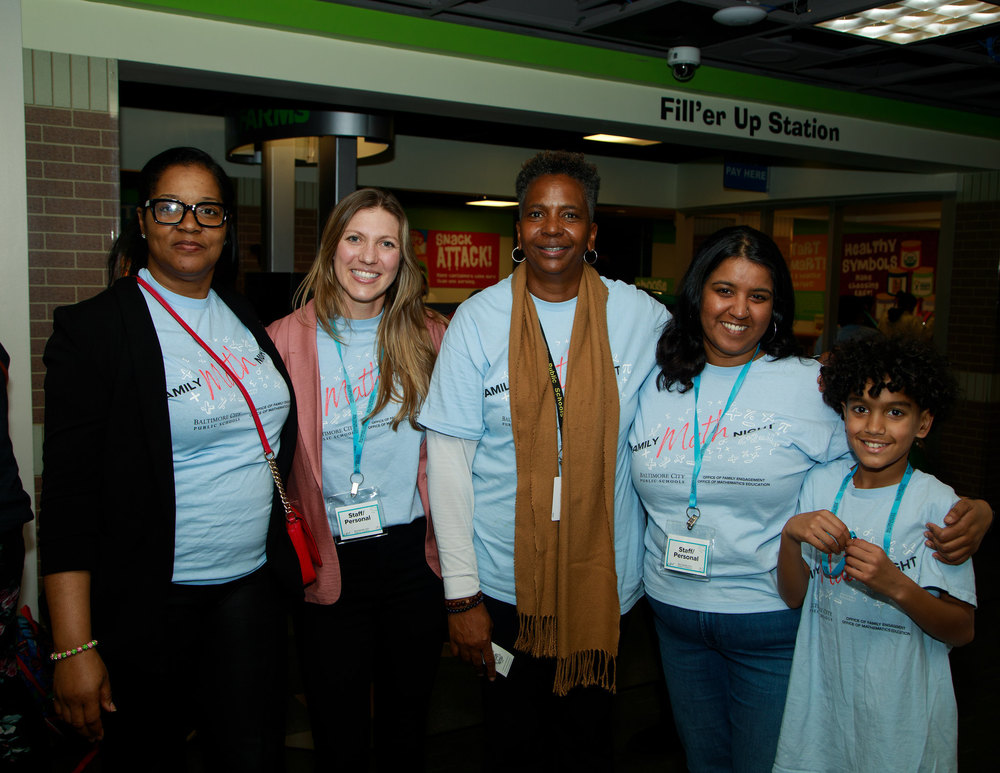 Family engagement staff poses for a picture in matching shirts at the Districtwide Math night at Port Discovery