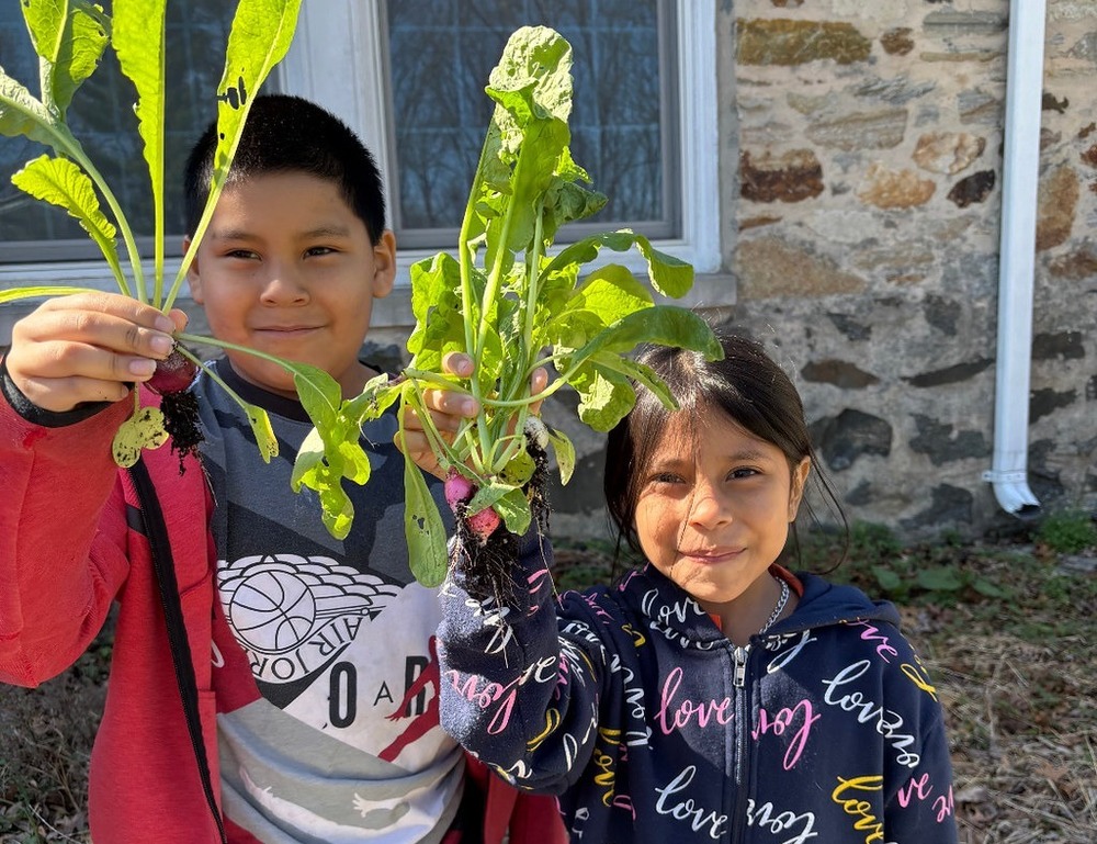 Two students holding plants at Great Kids Farm