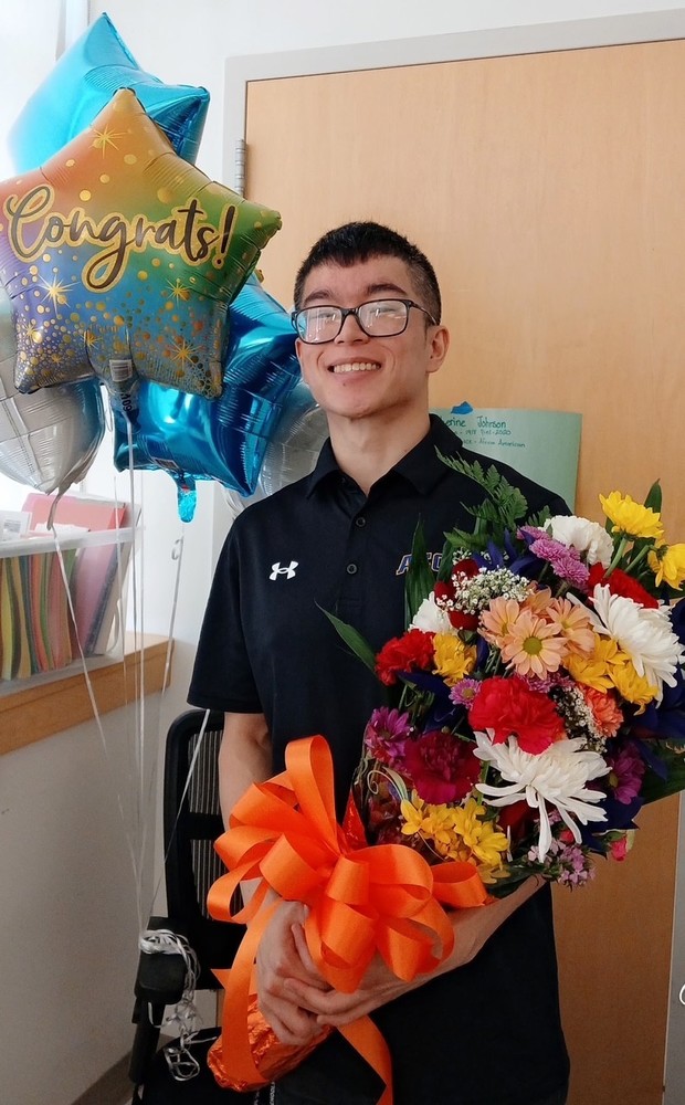 photo of last Teacher of the Year winner holding a bouquet and smiling