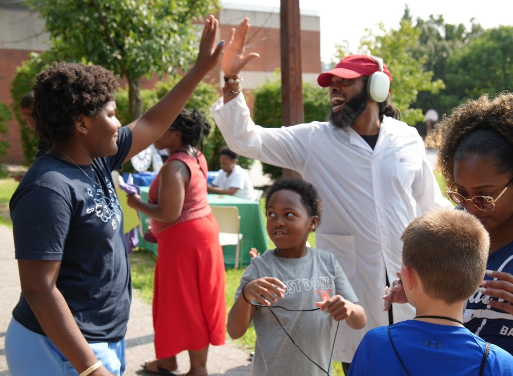 Staff member high fives a student at annual back to school bash.