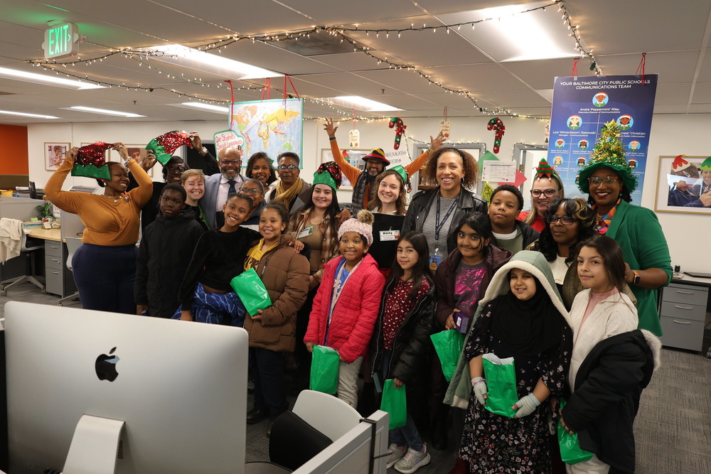 Students pose for a holiday pictures in the Office of Communications and Enrollment