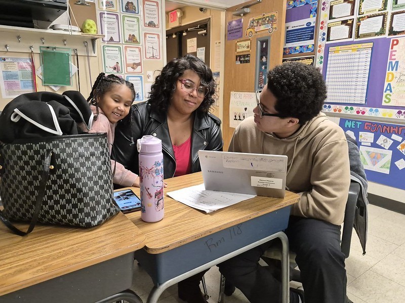 students and teacher having a discussion about an assignement