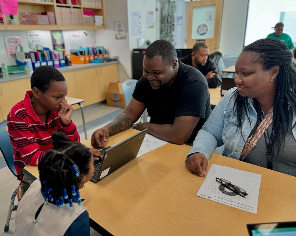 Student and family participate in a classroom learning exercise.