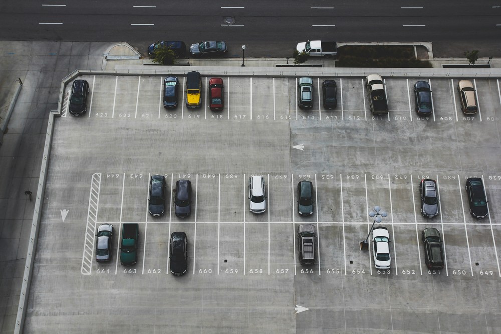 aerial view of parking lot with several cars parked in spaces