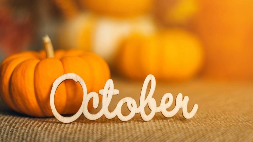 Wooden stencil of the word "October" surrounded by pumpkins