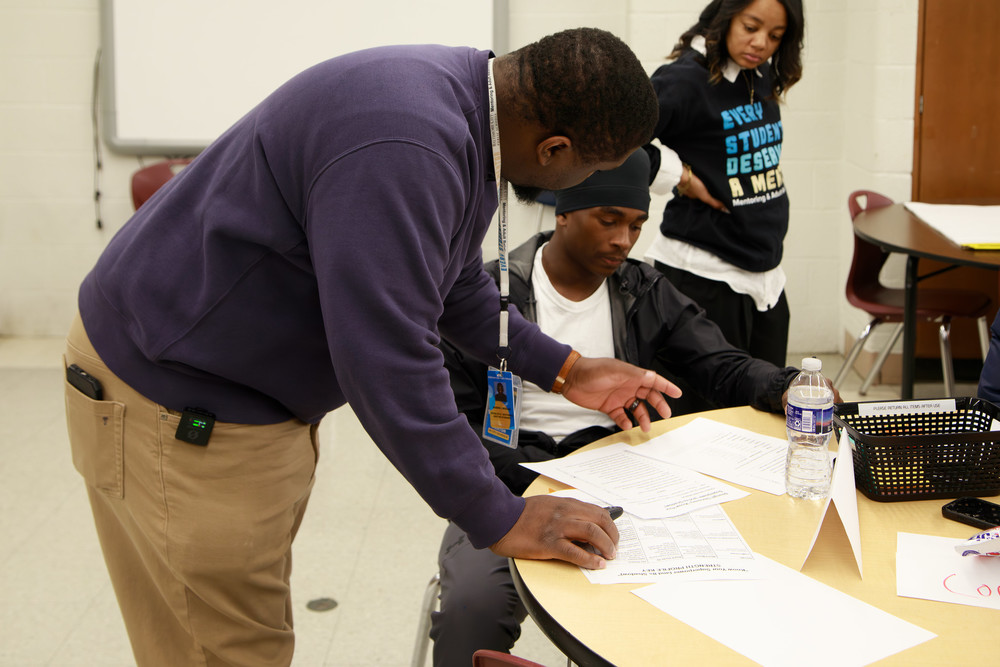 Student is assisted by teacher during class.