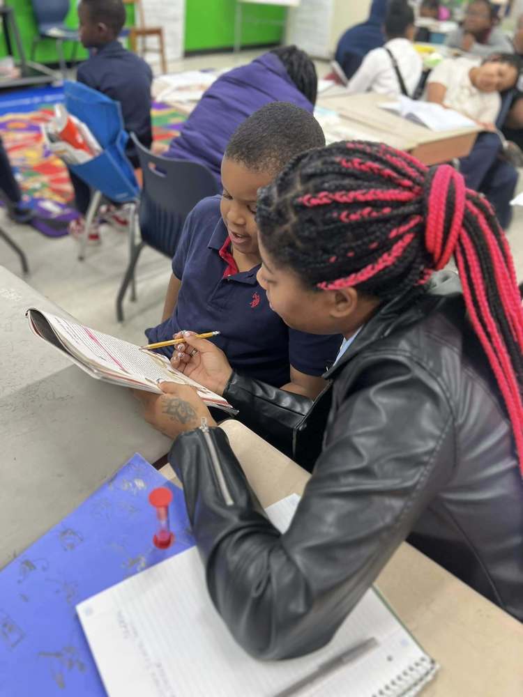 a volunteer is assisting a student with their learning exercise