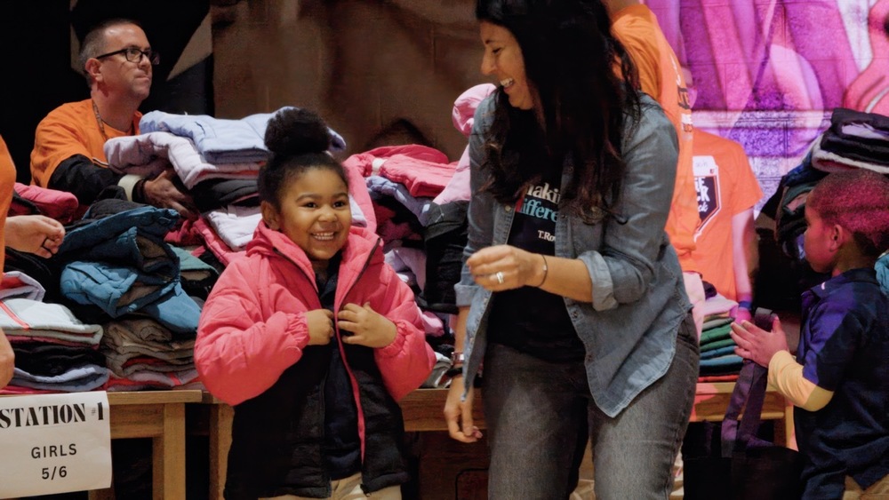 Harlem Park student smiles as they receive a coat during a coat drive.